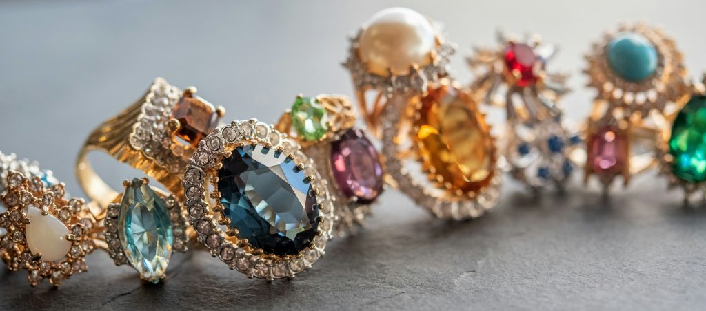 A picture of several different rings with varying designs and gemstone colors.